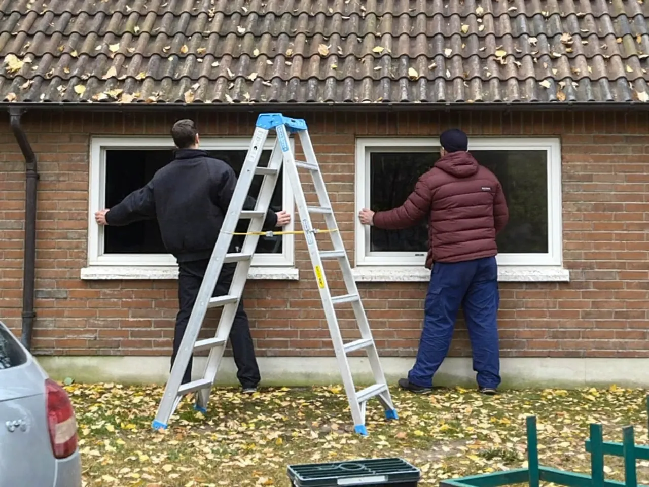 Installer fitting new windows to a UK home on a crisp autumn day